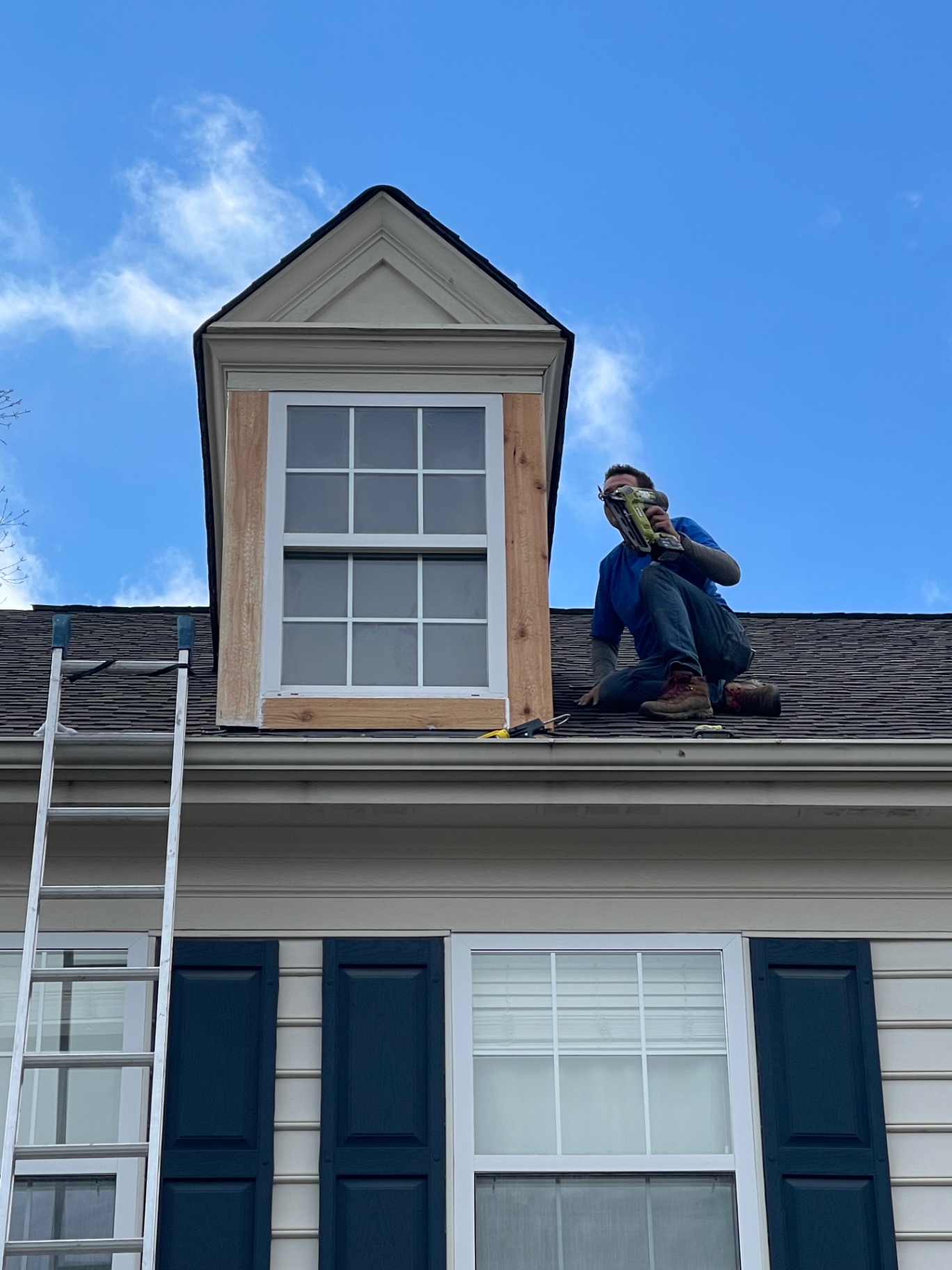 Contractor rebuilding a dormer with new wood trim