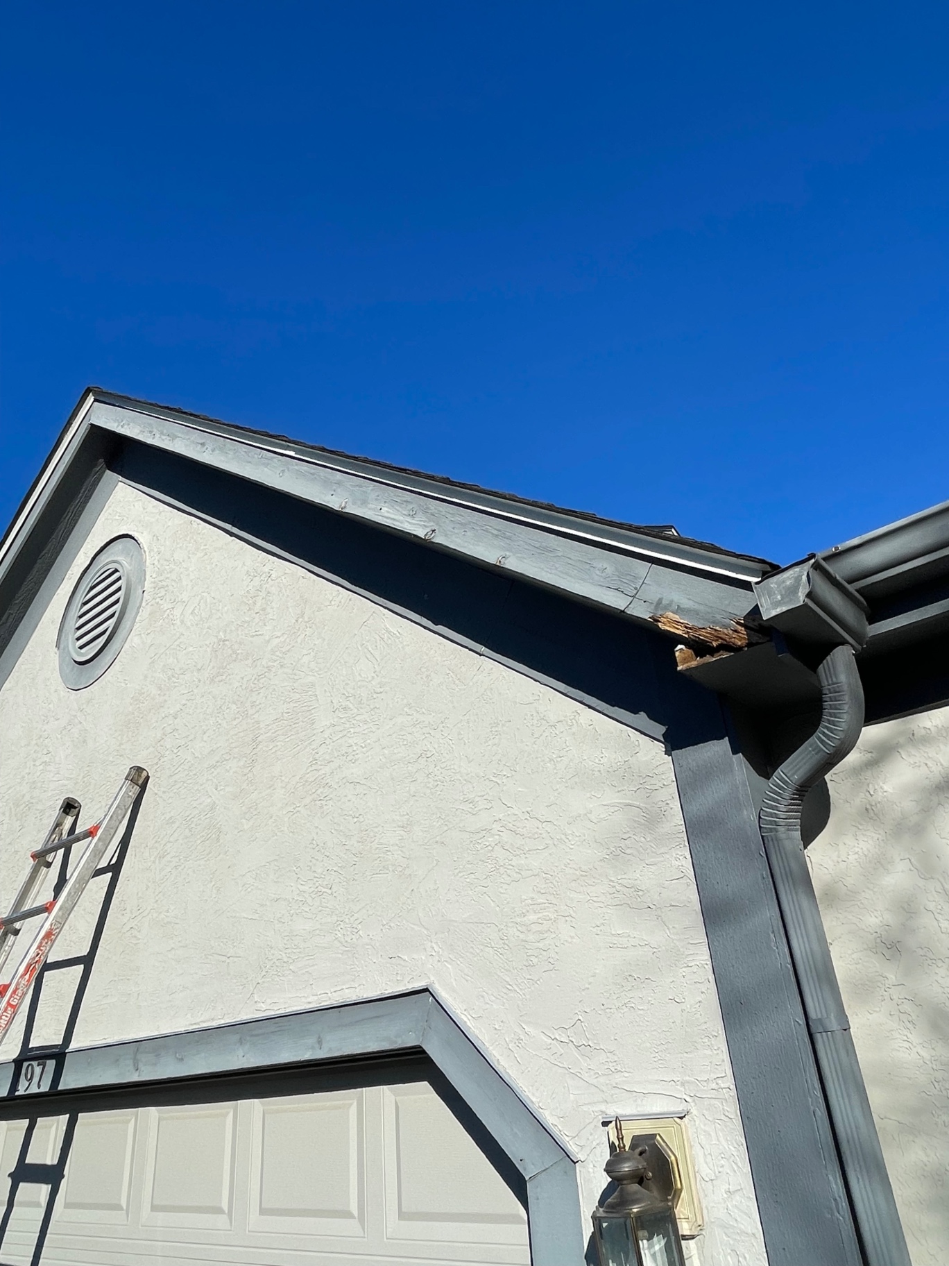 Rotten fascia board and wood damage at a gutter corner