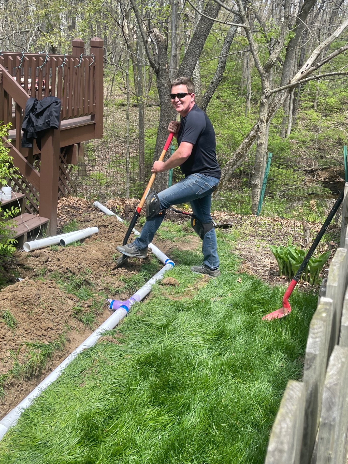Owner installing underground drain lines behind a home