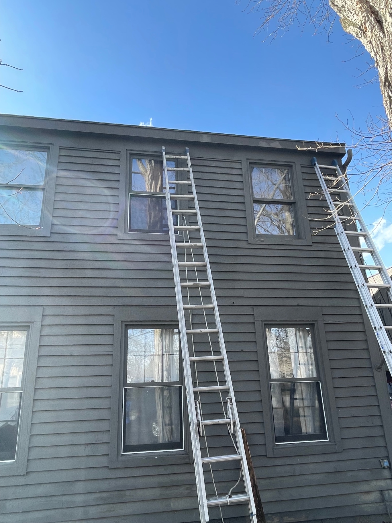 Two-story home with fresh fascia board being installed