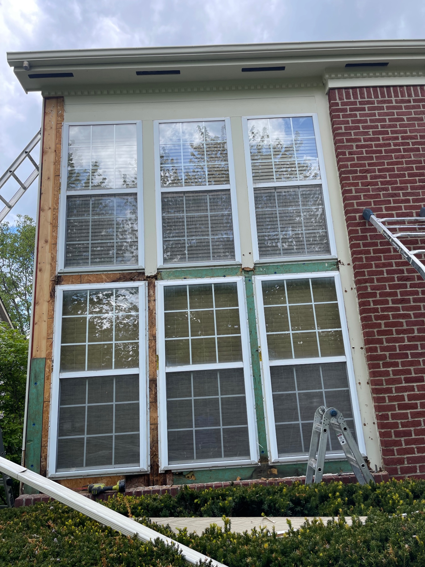Trim being replaced around three-window unit, fresh wood exposed